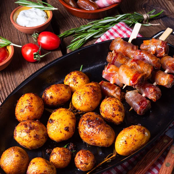 Rustikální datle zabalené do slaniny a mladé pečené brambory. — Stock fotografie