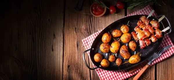 Fechas rústicas envueltas en tocino y patatas asadas jóvenes. —  Fotos de Stock