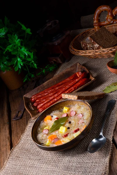 Сільський суп з квашеної капусти з беконом та ковбасою — стокове фото