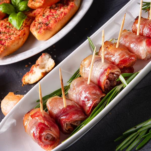 Dates wrapped in bacon and delicious tapas — Stock Photo, Image