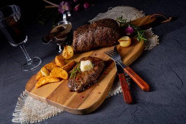 Otlar ve patates takozları ile tereyağı Beef Steak