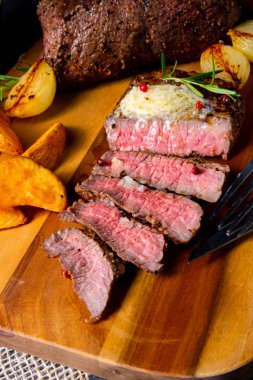 Rus usulü tereyağlı biftek, otlar ve patates dilimleri.