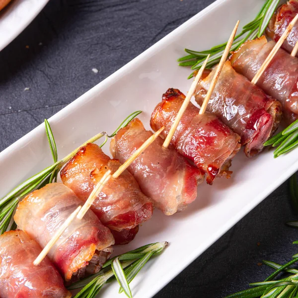 Dates wrapped in bacon and delicious tapas — Stock Photo, Image