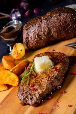 Otlar ve patates takozları ile tereyağı Beef Steak