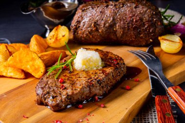 Otlar ve patates takozları ile tereyağı Beef Steak