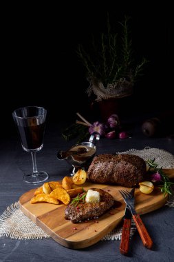 Otlar ve patates takozları ile tereyağı Beef Steak