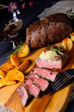 Rus usulü tereyağlı biftek, otlar ve patates dilimleri.