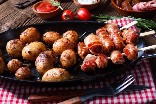 Rustic dates wrapped in bacon and young roasted potato. — Stock Photo, Image