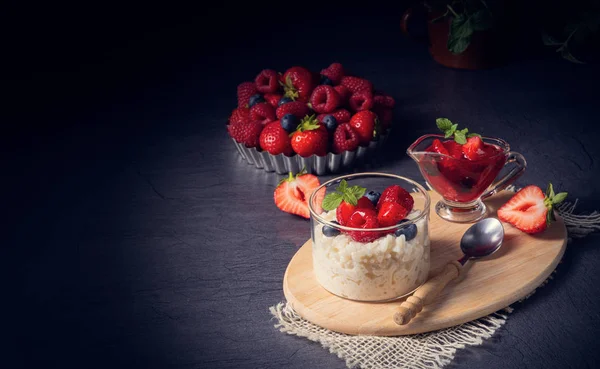 Heerlijke melkrijst met verschillende bessen en rode vruchtengelei — Stockfoto