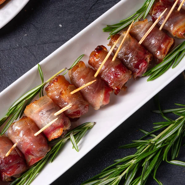 Dates wrapped in bacon and delicious tapas — Stock Photo, Image