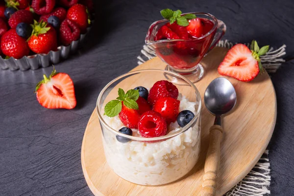 Смачний молочний рис з різними ягодами та червоним фруктовим желе — стокове фото