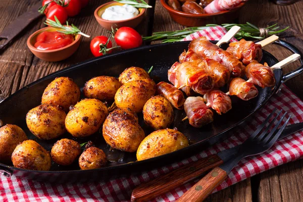 Rustic dates wrapped in bacon and young roasted potato. — Stock Photo, Image