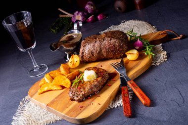 Otlar ve patates takozları ile tereyağı Beef Steak