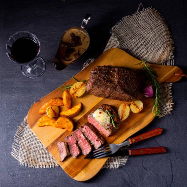 Rus usulü tereyağlı biftek, otlar ve patates dilimleri.