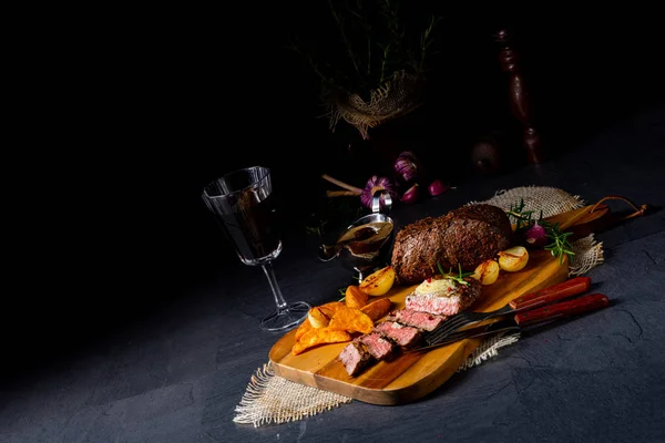 Filete de carne rústico de mantequilla mediana con hierbas y cuñas de patata — Foto de Stock