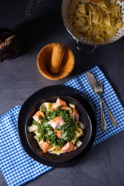 pappardelle pasta with creamed spinach and fried salmon clipart