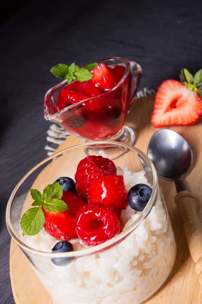 Delicious milk rice with different berries and red fruit jelly — Stock Photo, Image