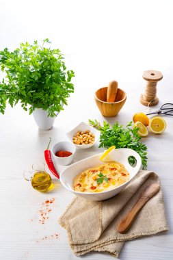 Beyaz arka planda limon ve biberli humus ezmesi.