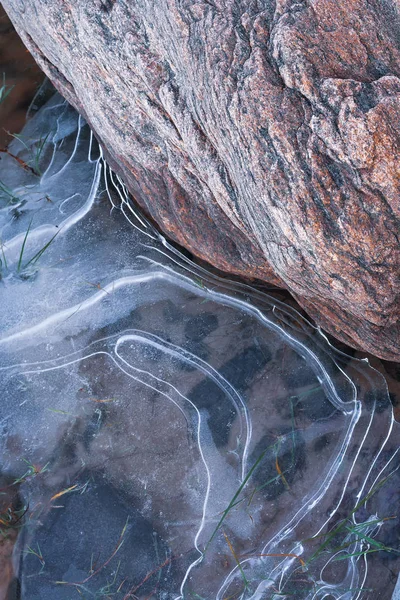 Stone in the ice on a sandy beach — Stock Photo, Image