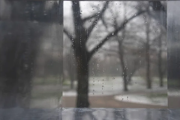 Winter park through a glass with drops — Stock Photo, Image