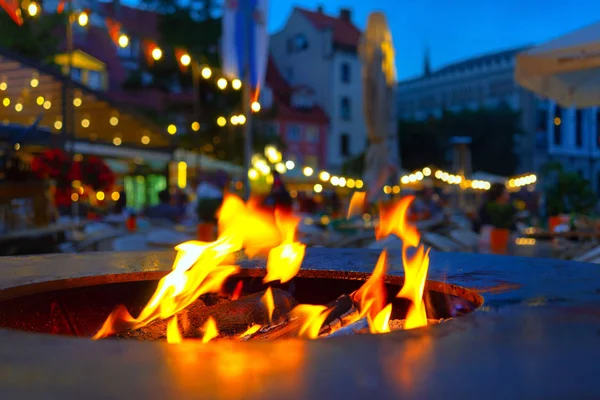 Fire burns with flames in the restaurants oven in Rigas square in the summer evening
