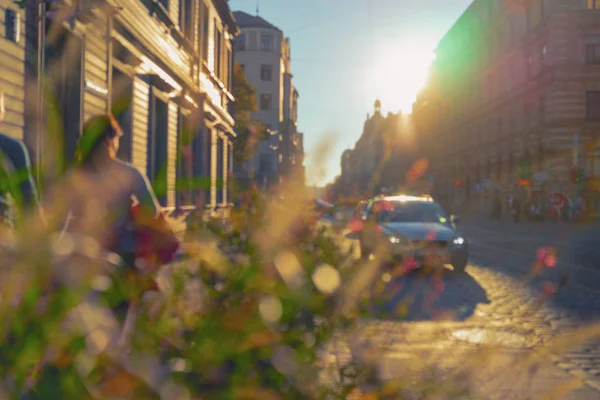 一对夫妇沿着街道在里加的城市在阳光明媚的一天旁边的汽车背光 — 图库照片