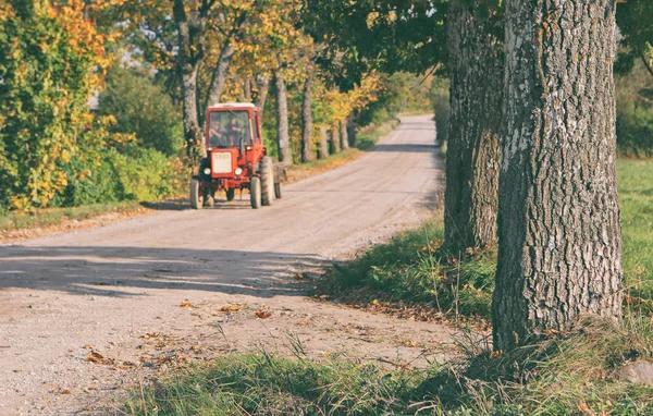 Trattore guida su strada rurale — Foto Stock