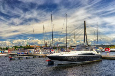 Yachts on the background of the city of Riga in the summer clipart