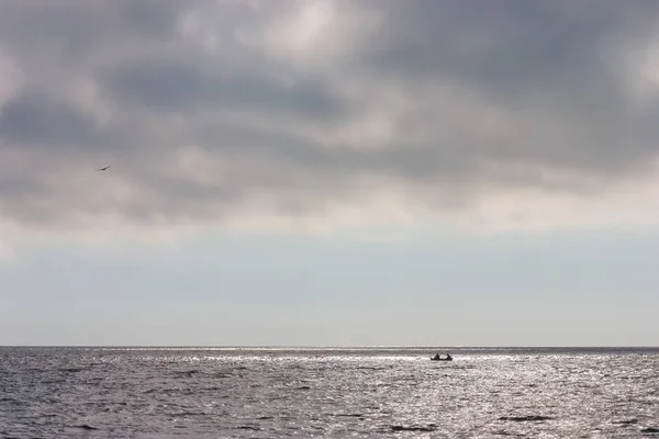 Két ember egy csónakban a láthatáron, a tengeren — Stock Fotó