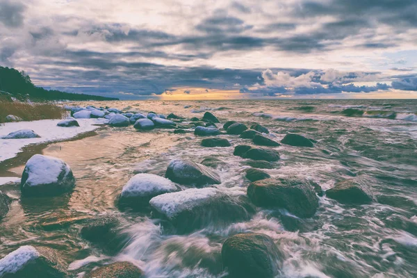 Piedras bajo la nieve en la costa báltica en invierno —  Fotos de Stock