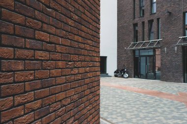 Motosiklet modern bir evin avlusunda duruyor.