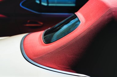 Otoparkta kırmızı çatılı bir Cabriolet.