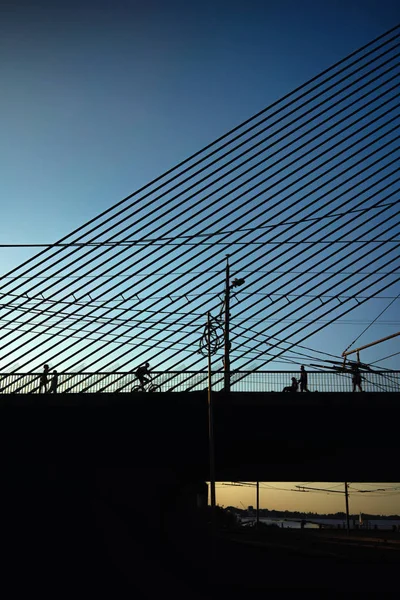 Bridge at sunset with silhouettes — Stock Photo, Image