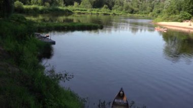 Mavi Gauja nehrindeki bir teknenin arka planında kumaştan yapılmış parlak renkli hamak sıcak bir yaz gününde.