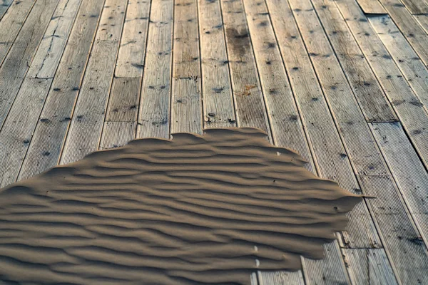 Arena en una terraza de madera en la playa — Foto de Stock