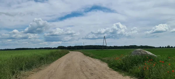 Lettország mezőgazdasági területei közötti földút. — Stock Fotó