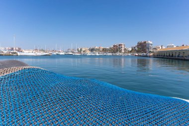 Gölün arka planında yatlı balık ağı var.