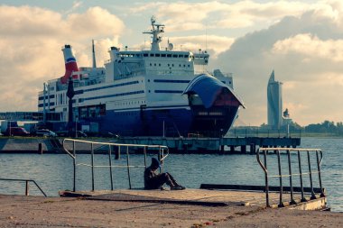 Riga limanında bir adam vapurunu bekliyor. Yolcu feribotu yolcuları ve ulaşımı Daugava Nehri 'ne bindirir. Yaz günü. Letonya, Baltık Denizi