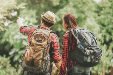 Gün ışığında bir şey onların tatil gezisi ormanındaki sırasında bakarak bacpack ile Asya çift Gezgin görünümünü geri 