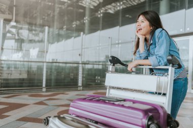 Mutlu genç çekici Asyalı kadın yolcu Bagaj arabası havaalanından geçirecekkimliği yürüyüş ile