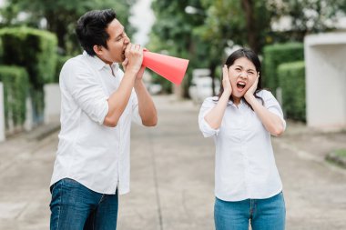 Asya adam çığlık ve Asyalı kadın açık bağırarak megafon kullanın