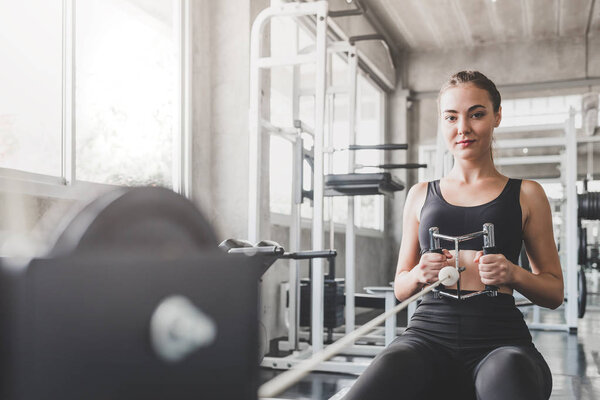 Beautiful young healthy caucasian woman exercising in gym