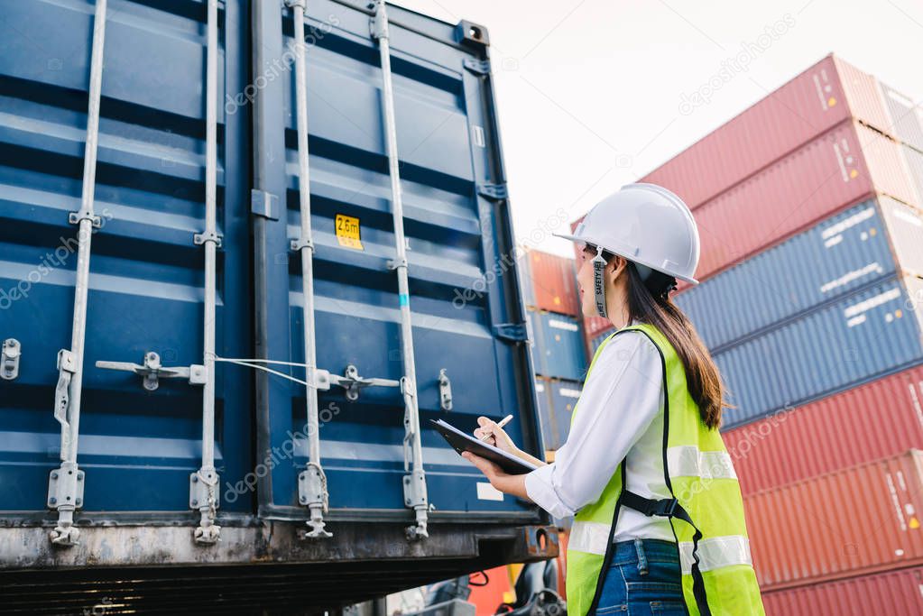 Asian staff woman checking container box for logistic Import Export in dock