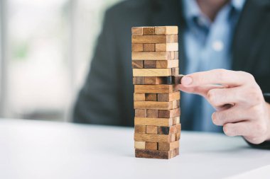 El Ahşap ahşap blok Kulesi bloğundan çekerek işadamı. iş riski veya planlama stratejisi kavramı