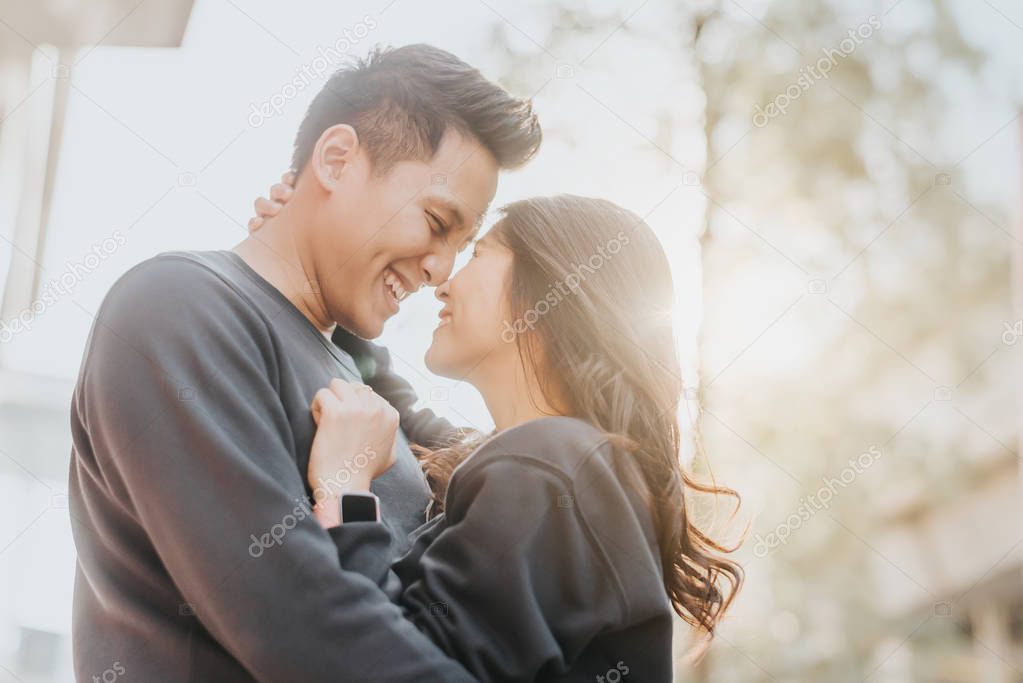 Happy Asian couple in love having fun and embracing outdoor in city