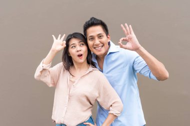 Jest ile gülümseyen mutlu Asya çift ok 