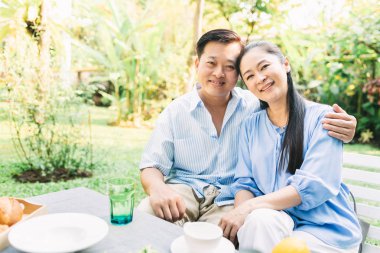  Asyalı çift bahçede sarılıyor. 