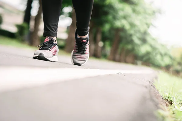 公園の道路を走るランナーの足 — ストック写真