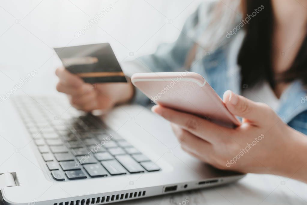 hands holding a credit card and using smart phone for online sho