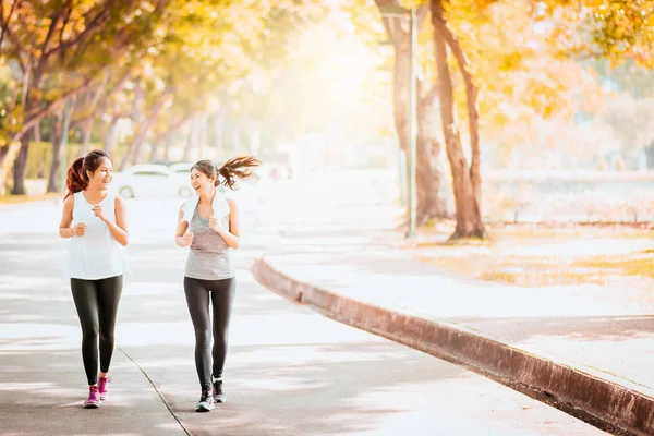 Healthy Asian girlfriend jogging together in park